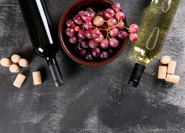 Top view wine bottles with grape and copy space on black stone  horizontal