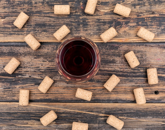 Foto gratuita bicchiere di vino vista dall'alto su orizzontale in legno scuro