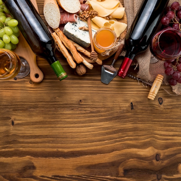 Foto gratuita vista dall'alto vino con cibo e grappolo d'uva