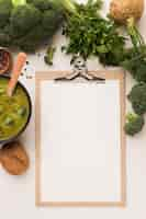 Foto gratuita vista dall'alto della zuppa di broccoli invernali con blocco note e sedano