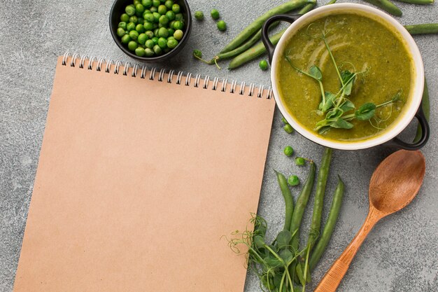Top view of winter peas soup in bowl with notebook