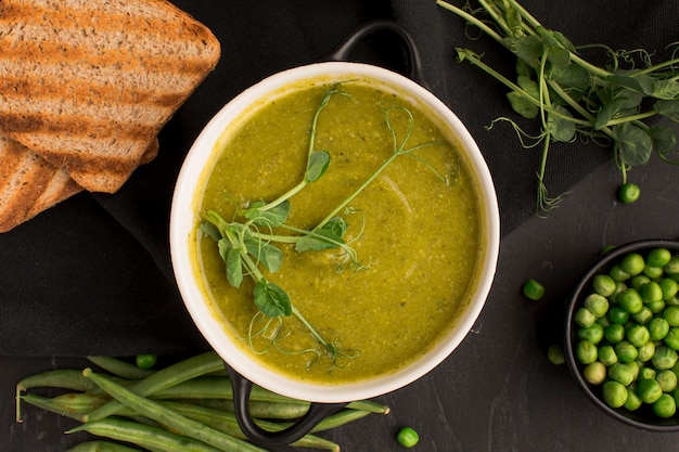 Top view of winter peas soup in bowl with toast