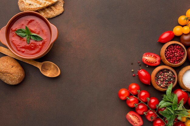 Top view of winter tomato soup in bowl with toast and copy space