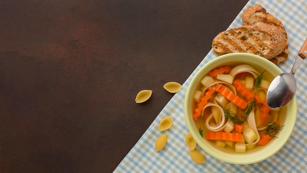 Top view of winter vegetables soup in bowl with toast and copy space