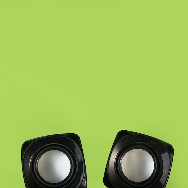 Free photo top view of wireless speaker on green background