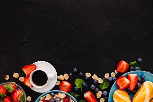 黒い木製の背景に健康的な朝食の上にコピースペース平面図