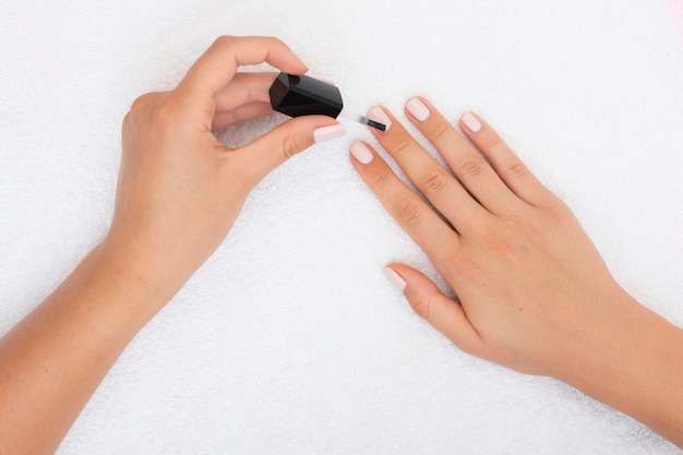 Top view woman applying nail polish