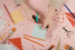 Free photo top view of woman cutting blue paper