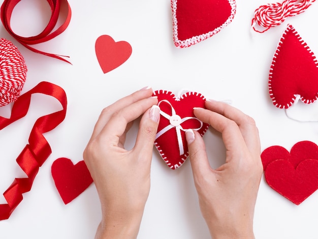 Foto gratuita vista superiore della donna che decora i cuori rossi