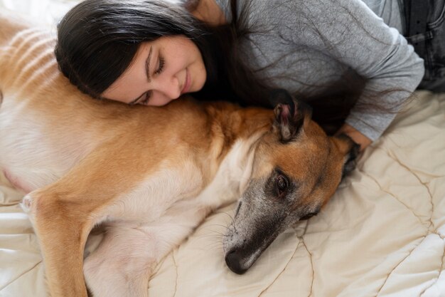 トップ ビューの女性とベッドで犬