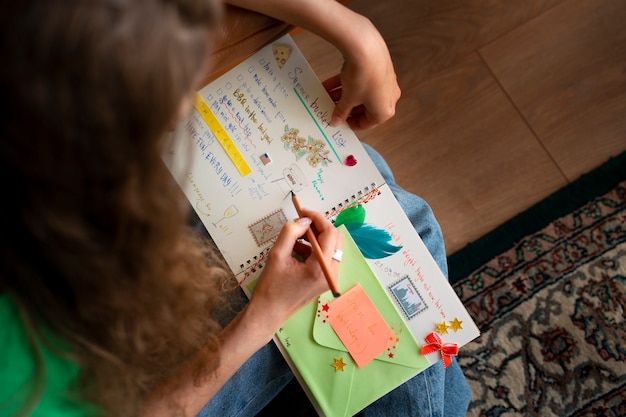 Free photo top view woman doing creative journaling