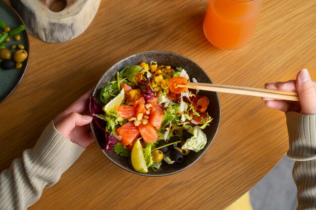 Top view woman eating salmon bowl
