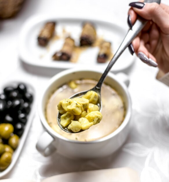 Top view woman eating traditional azeri dish dushbara with olives