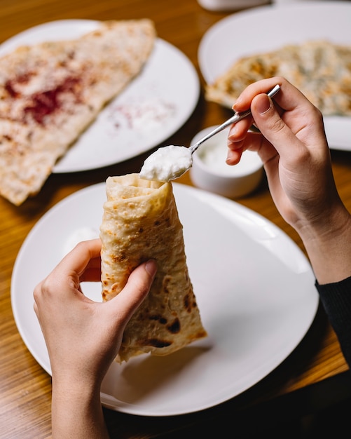 トップビューの女性はヨーグルトとkutabを食べる