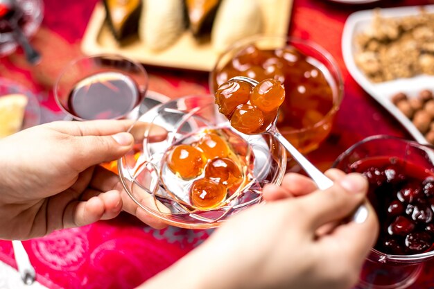 Top view woman eats white cherry jam with tea