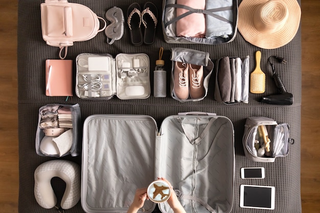 Top view woman hands getting ready to travel vacation packing suitcase use konmari method