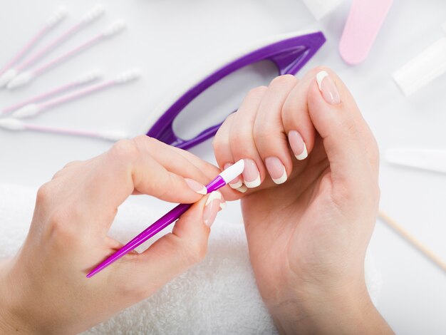 Top view woman hands using manicure tools