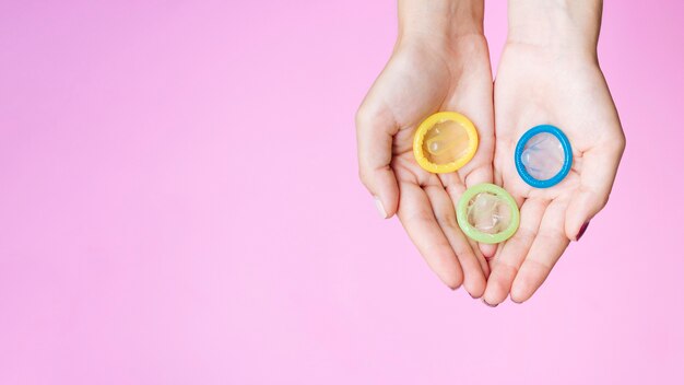 Top view woman holding colourful condoms