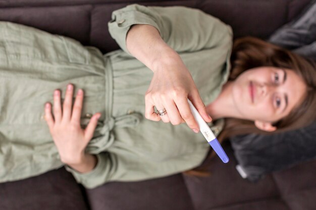 Top view woman holding pregnancy test
