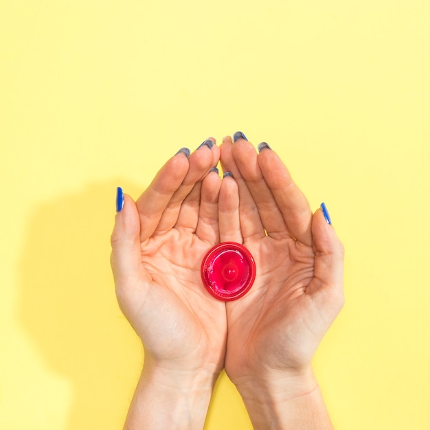 Top view woman holding a red condom