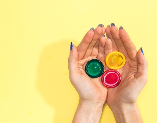 Top view woman holding three condoms