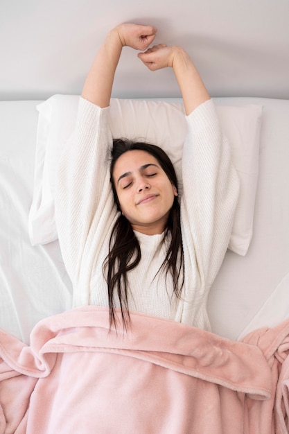 Free photo top view woman laying in bed