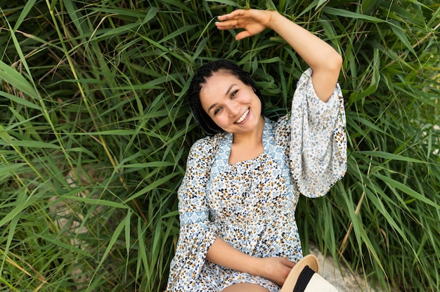 Foto gratuita donna di vista superiore che pone sull'erba