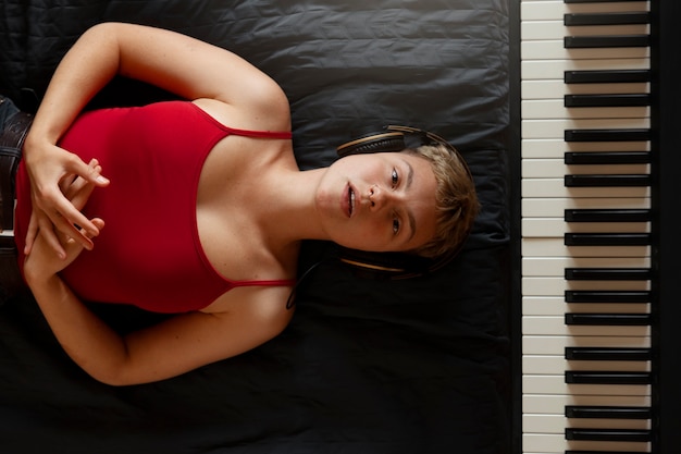 Top view woman laying near the piano
