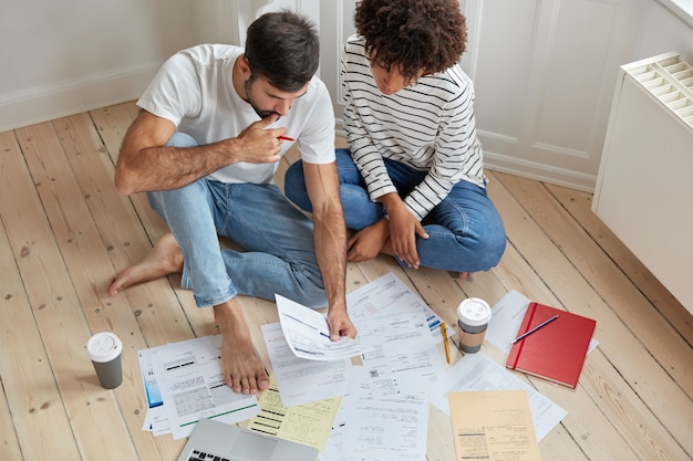 Top view of woman and man colleagues have conversation about common project, study documents