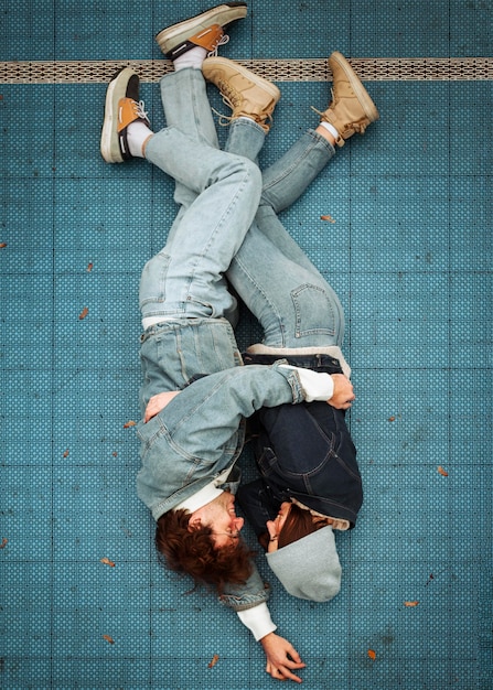 Free photo top view woman and man lying on the floor while hugging