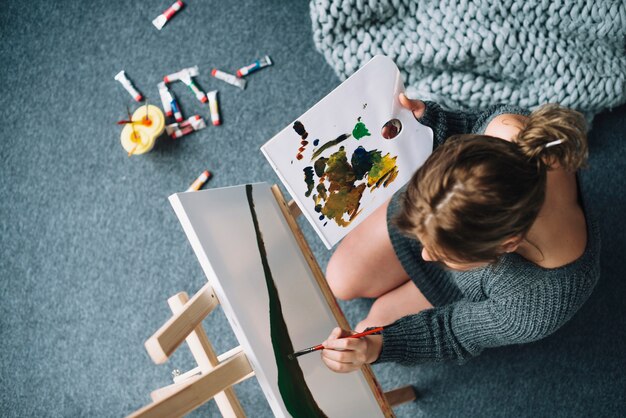 Top view of woman painting at home