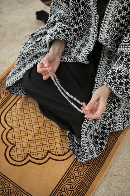 Вид сверху женщина молится на ковре