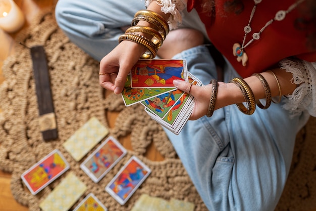 Free photo top view woman reading tarot at home