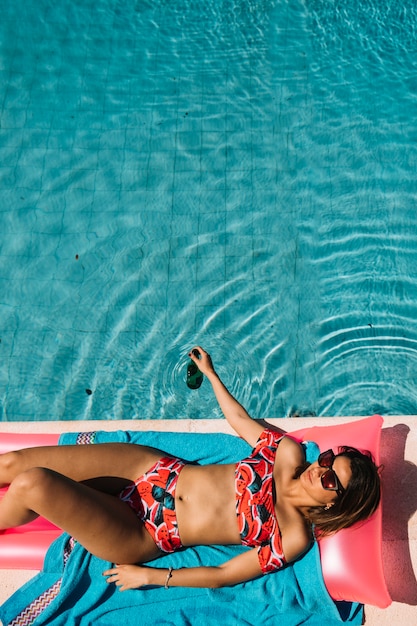 Top view of woman relaxing next to pool