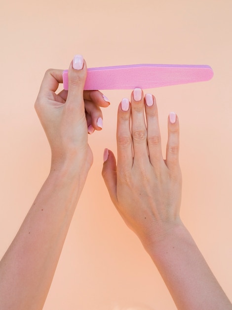 Top view woman's hands using nail file