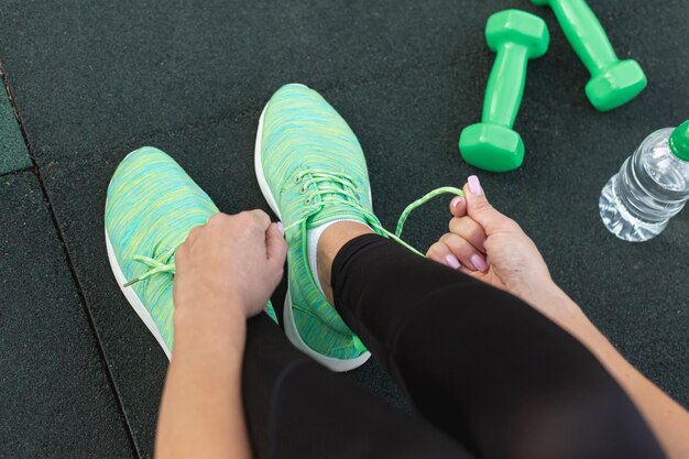 Top view woman tying her green sneakers