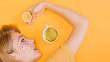 Free photo top view of woman with cup and lemonade in yellow scene