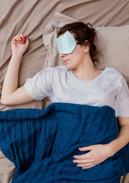 Top view woman with sleeping mask sleeping