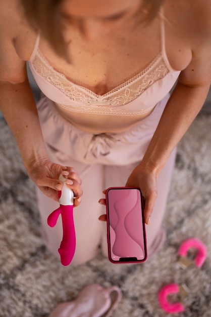 Top view woman with smartphone and vibrator