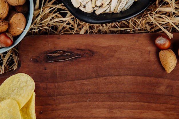 Top view of a wood board and beer snacks on straw