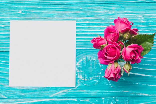 Top view of wooden background with paper and flowers