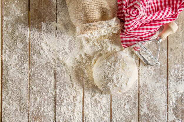 Top view of wooden boards with flour and dough