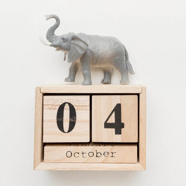 Top view of wooden calendar with elephant figurine on top for animal day