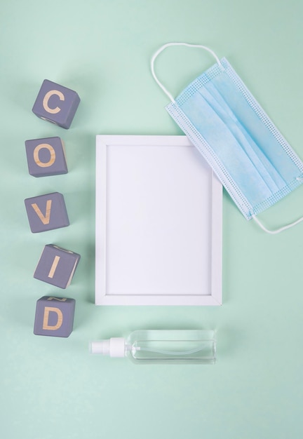 Top view of wooden cubes with covid and frame next to medical mask