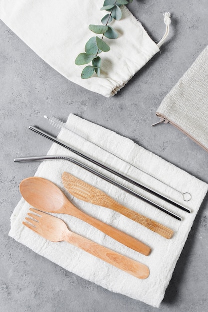 Top view wooden cutlery and metallic straws