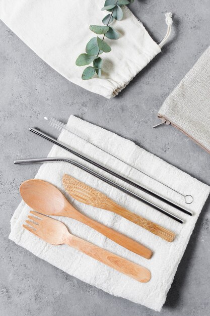 Top view wooden cutlery and metallic straws