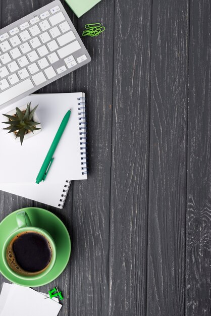 Top view of wooden desk with coffee cup and stationery