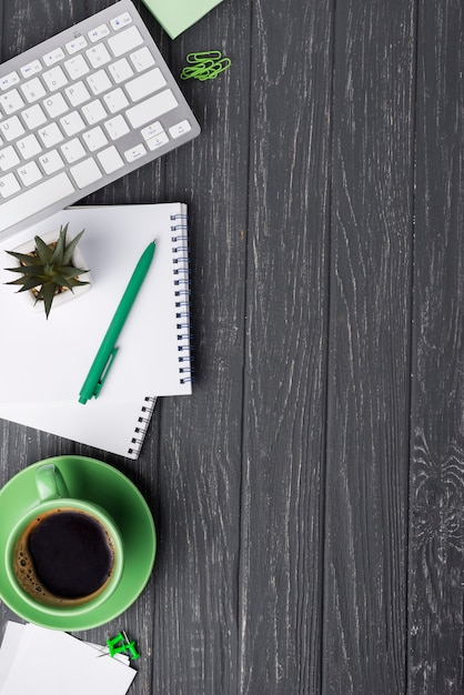 Top view of wooden desk with coffee cup and stationery