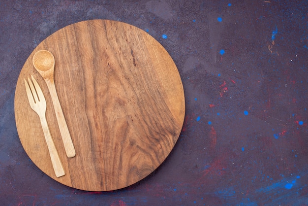 Top view wooden fork spoon on the dark surface wood wooden cutlery desk