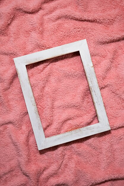 Top view wooden frame on pink blanket